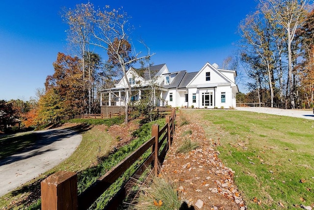 view of front of property featuring concrete driveway and a front lawn