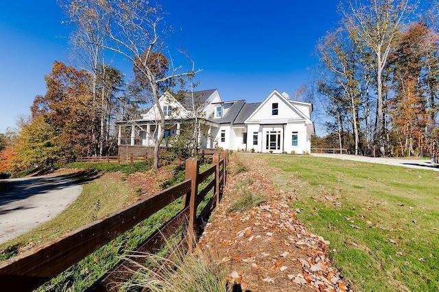 view of front of house with a front yard and fence