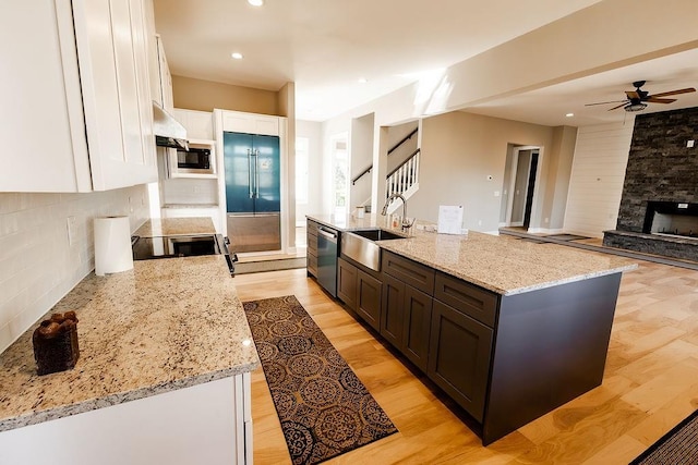 kitchen with ceiling fan, dishwasher, light wood-style flooring, white cabinetry, and a sink