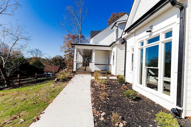 property entrance with fence and covered porch