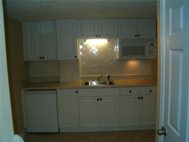 kitchen with white cabinets, decorative backsplash, white appliances, and sink