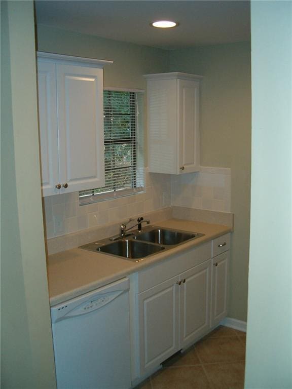 kitchen with decorative backsplash, dishwasher, sink, and white cabinets