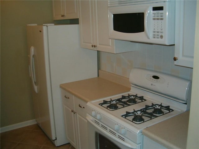 kitchen with tile patterned flooring, decorative backsplash, white appliances, and white cabinetry