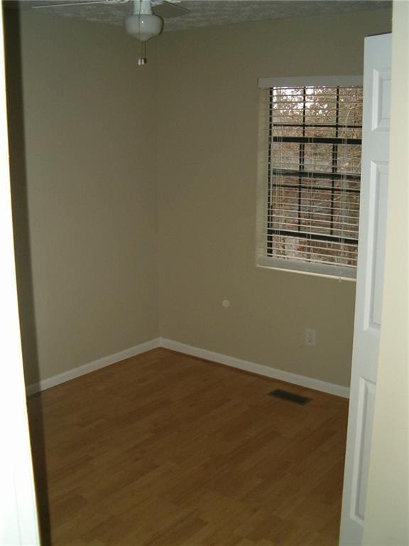 spare room with hardwood / wood-style flooring and ceiling fan