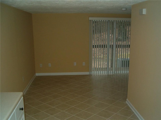 empty room featuring light tile patterned floors and a textured ceiling