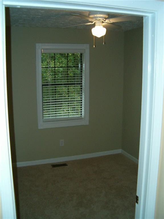 spare room featuring carpet floors and ceiling fan