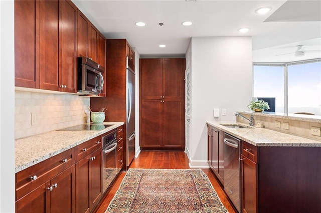 2795 Peachtree Rd NE Unit 2101, Atlanta, GA 30305 - kitchen featuring appliances with stainless steel finishes, a sink, dark wood finished floors, decorative backsplash, and a peninsula