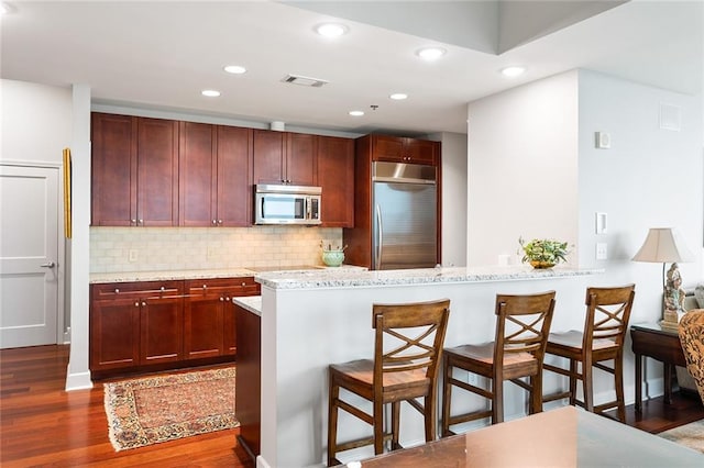 2795 Peachtree Rd NE Unit 2101, Atlanta, GA 30305 - kitchen featuring stainless steel appliances, a kitchen bar, dark wood-style flooring, backsplash, and recessed lighting