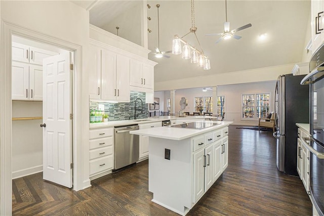 kitchen with sink, white cabinetry, stainless steel dishwasher, kitchen peninsula, and a kitchen island