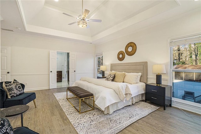 bedroom with a tray ceiling, ceiling fan, and hardwood / wood-style flooring