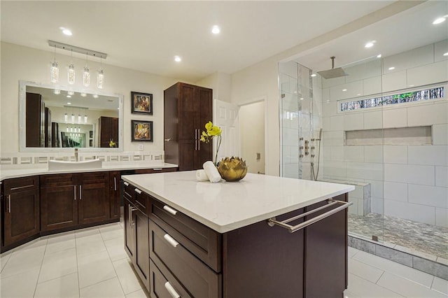 bathroom with vanity, tile patterned flooring, and a tile shower