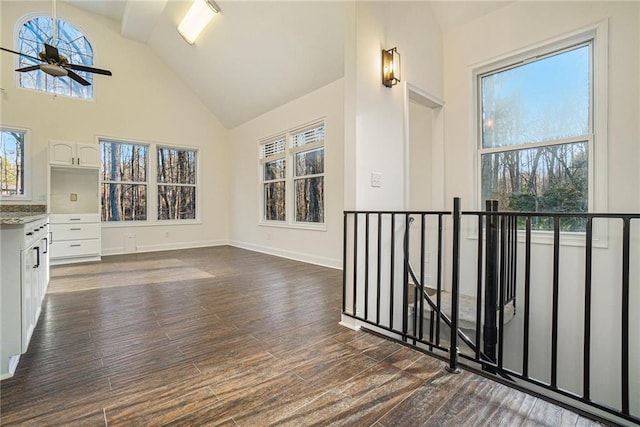 interior space featuring dark hardwood / wood-style flooring, high vaulted ceiling, and ceiling fan