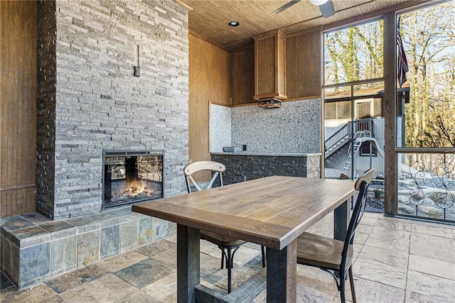 dining area featuring wood ceiling, a fireplace, and ceiling fan