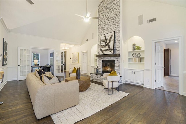 living room featuring ceiling fan, dark wood-type flooring, built in features, and a fireplace