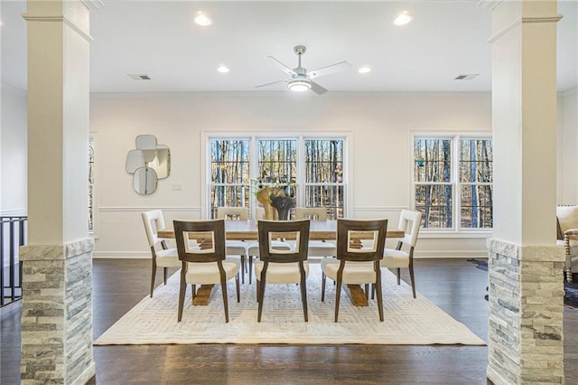 dining space featuring decorative columns, ceiling fan, crown molding, and dark hardwood / wood-style flooring