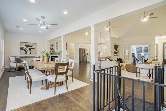 dining area featuring decorative columns, crown molding, dark hardwood / wood-style floors, and ceiling fan