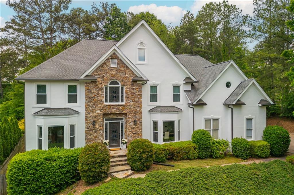 725 Eider Down Ct, Alpharetta, GA 30022 - colonial home with a shingled roof, stone siding, and stucco siding