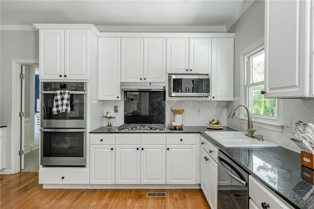 kitchen featuring light wood-style floors, a sink, white cabinetry, and stainless steel appliances