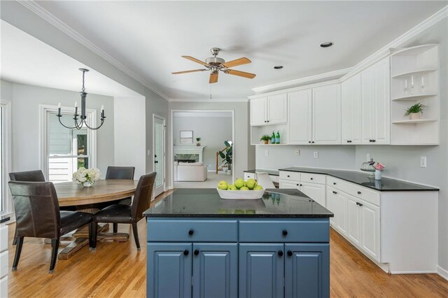 kitchen with open shelves, dark countertops, and blue cabinetry