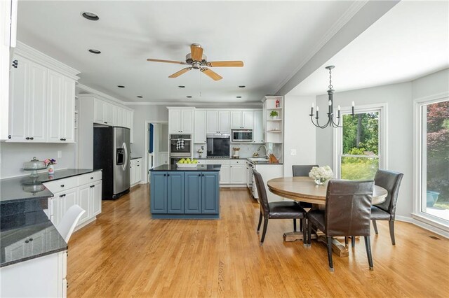 kitchen featuring appliances with stainless steel finishes, a center island, open shelves, white cabinets, and light wood-style floors