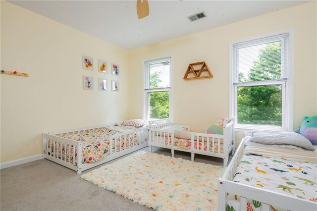 bedroom featuring carpet floors, baseboards, a ceiling fan, and visible vents