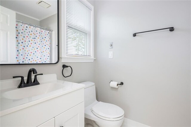 bathroom with crown molding, vanity, toilet, a shower with shower curtain, and visible vents