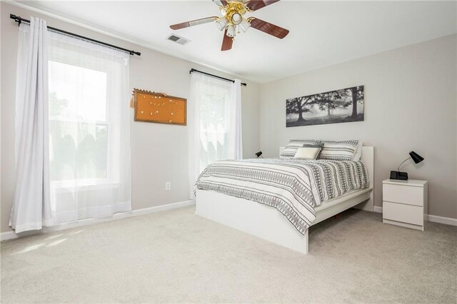 bedroom with carpet floors, a ceiling fan, baseboards, and visible vents