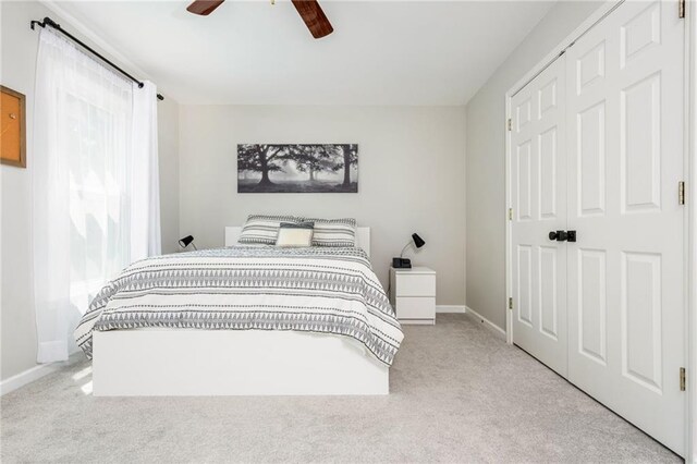 bedroom with a ceiling fan, baseboards, and carpet
