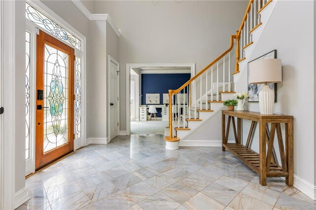 entryway featuring baseboards, marble finish floor, a healthy amount of sunlight, and stairway