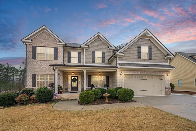 craftsman-style house with covered porch, a garage, and a lawn