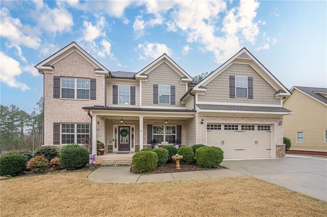 craftsman-style house with a garage, covered porch, and a front yard