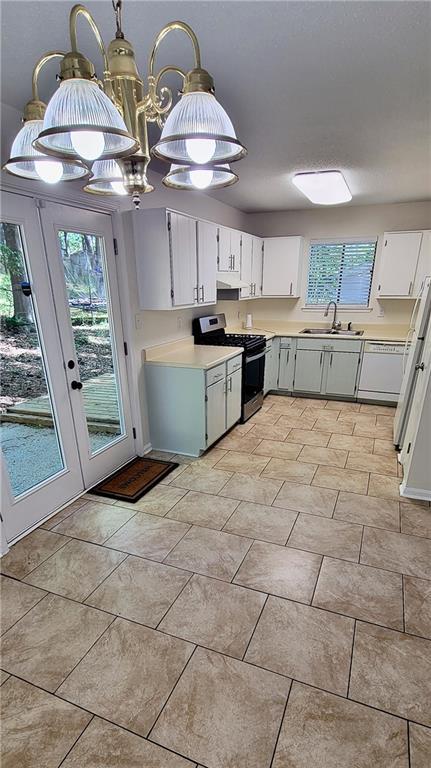 849 Cadet Ct NW, Lilburn, GA 30047 - kitchen featuring light countertops, white cabinets, a sink, and white appliances