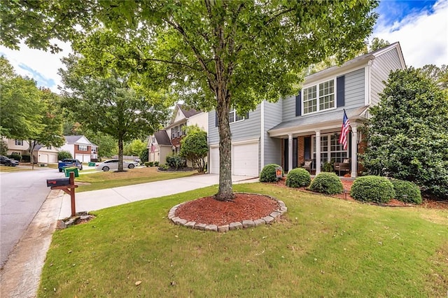 colonial inspired home with covered porch, a garage, and a front lawn