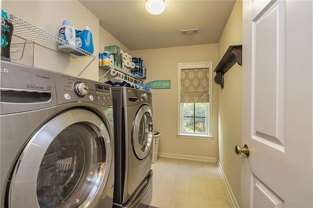 clothes washing area with a textured ceiling and washing machine and clothes dryer