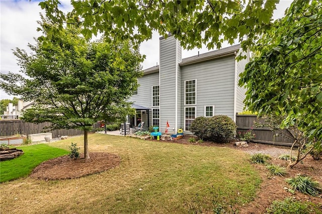 back of house featuring a lawn and a patio area