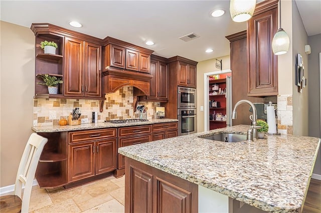 kitchen with a kitchen breakfast bar, sink, hanging light fixtures, and appliances with stainless steel finishes