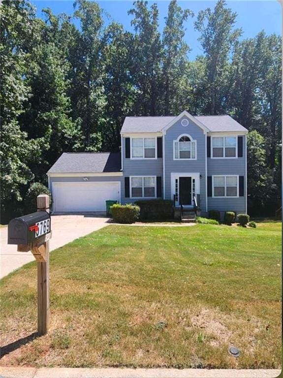 colonial home with a garage and a front yard