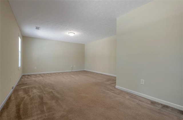 empty room featuring carpet and a textured ceiling