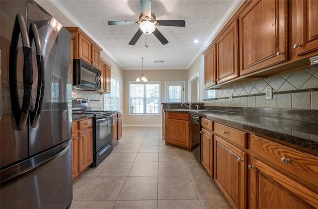 kitchen featuring hanging light fixtures, backsplash, black appliances, crown molding, and light tile patterned floors