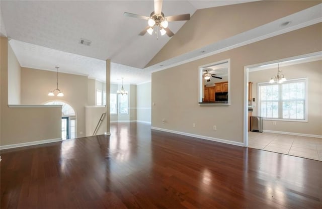 unfurnished living room featuring high vaulted ceiling, light hardwood / wood-style flooring, a textured ceiling, and ceiling fan with notable chandelier