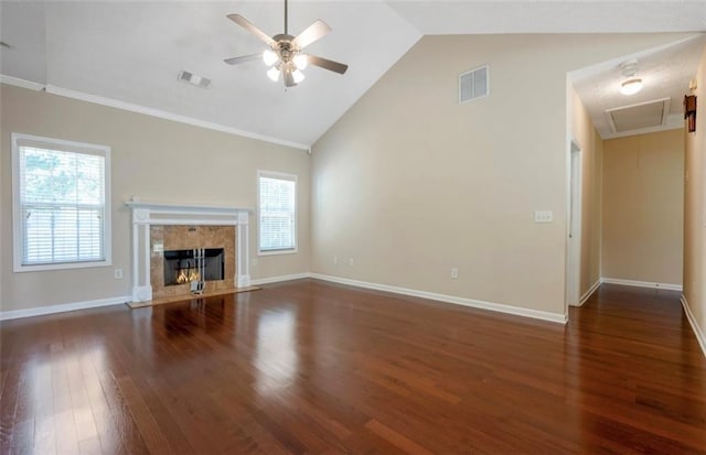 unfurnished living room featuring lofted ceiling, ceiling fan, a premium fireplace, dark wood-type flooring, and crown molding