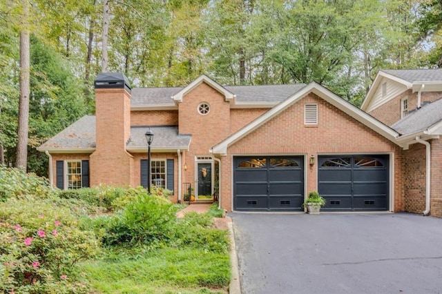 2 Pointe Ter SE, Atlanta, GA 30339 - view of front of house with an attached garage, asphalt driveway, brick siding, a chimney, and roof with shingles