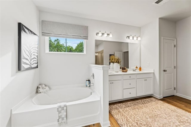 817 Dobby Way, Mcdonough, GA 30252 - full bath featuring double vanity, a garden tub, wood finished floors, and a shower