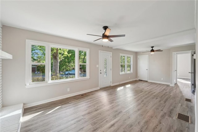 unfurnished living room with ceiling fan, light wood finished floors, and baseboards