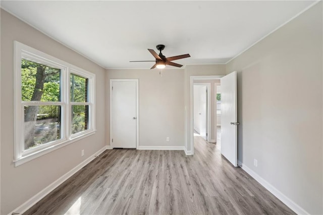 unfurnished bedroom with wood finished floors, baseboards, and a ceiling fan
