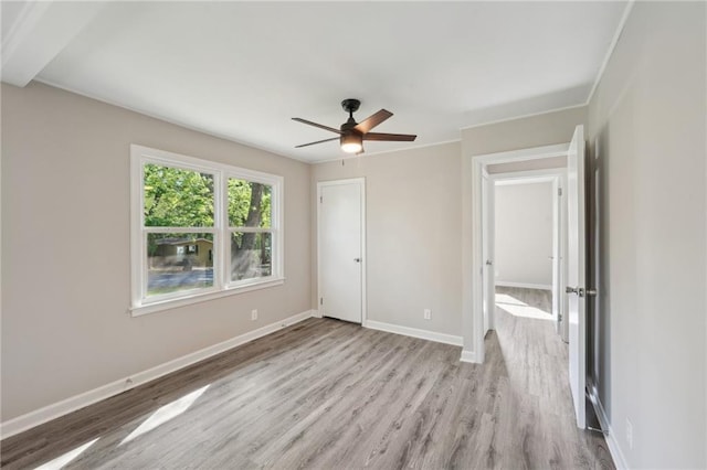 unfurnished bedroom with wood finished floors, baseboards, and a ceiling fan
