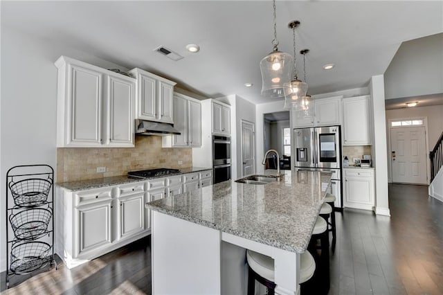 4825 Odum View Ln, Cumming, GA 30040 - kitchen with appliances with stainless steel finishes, a sink, under cabinet range hood, a breakfast bar area, and white cabinets