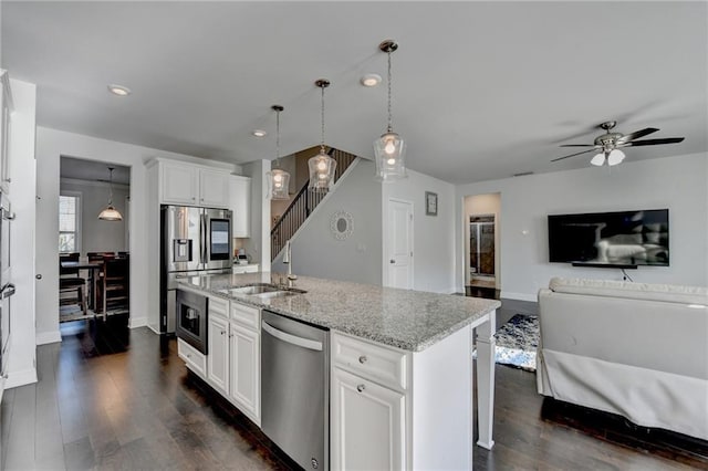 4825 Odum View Ln, Cumming, GA 30040 - kitchen with stainless steel appliances, a sink, open floor plan, dark wood-style flooring, and light stone countertops