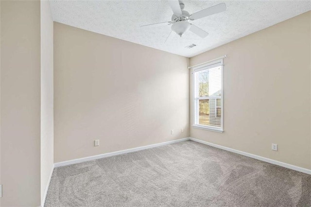 carpeted empty room featuring a textured ceiling, a ceiling fan, visible vents, and baseboards