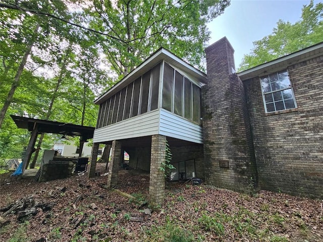 12 Lakemont Dr SE, Silver Creek, GA 30173 - back of property with a sunroom, a chimney, and brick siding